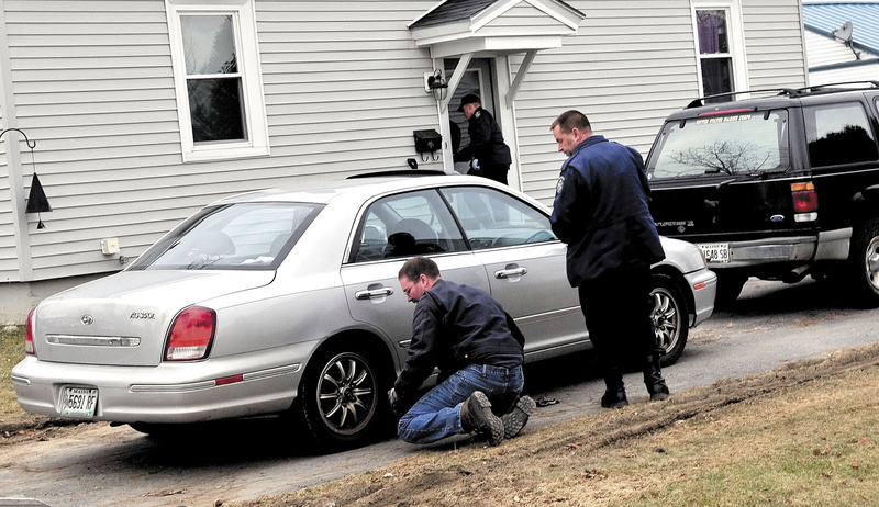 Maine State Police Detective Scott Bryant, right, watches as a tow truck operator hooks on to the first of two vehicles that were taken from 29 Violette Ave. in Waterville on Monday. The home has been subject to an intense investigation for 20-month-old Ayla Reynolds, who has been missing since last Friday. The girl and her father, Justin DiPietro, live at the home.