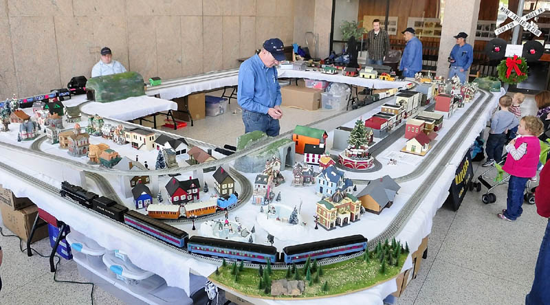 THE POLAR EXPRESS: People observe the finer details of the display. Friday afternoon outside the Maine State Museum in Augusta. The Great Falls Model Railroad Club of Auburn and Augusta’s Maine 3-Railers will display their trains in the Cultural Building atrium again from 10 a.m. to 3 p.m. today. Museum admission is free. It is located at 230 State St., beside the State House.