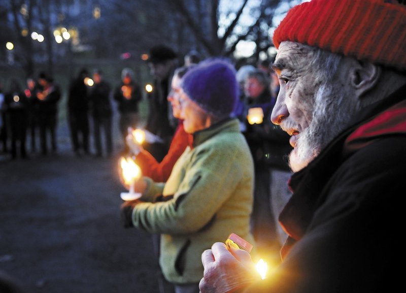 SUPPORT: Charles Acker, of Whitefield, holds a candle Sunday during a vigil with members of several local church congregations to show solidarity with the Occupy Augusta members at Capitol Park in Augusta.