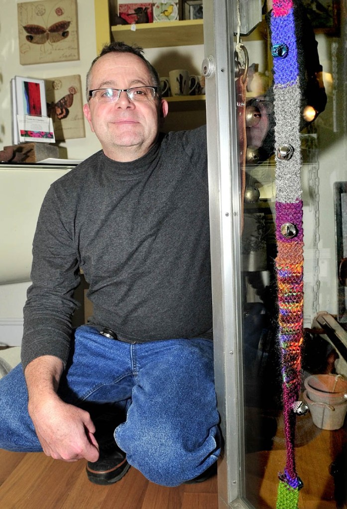 A GOOD YARN: David Ellis, owner of the Wish shop in Skowhegan, found this knitted belt of yarn and bells on the front door of his store Saturday. Twenty other town businesses were targets of "yarn bombing," where colorful yarn items are left to brighten the urban landscape.