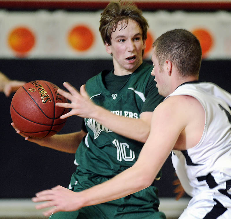 COMING THROUGH: Winthrop High School’s Taylor Morang, left, attempts to dribble past Hall-Dale High School’s Tyler French during a game Mondayin Farmingdale.
