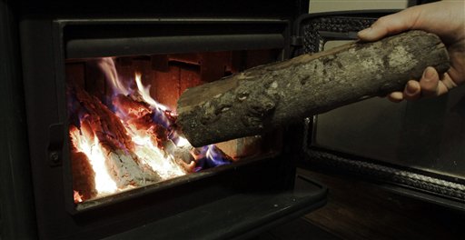 Dan Stevens loads the wood stove at his home in Gardiner last Thursday. The number of households using wood as a heating source nearly doubled in Maine from 2000 to 2010, while growing by a third nationwide, according to U.S. Census figures.