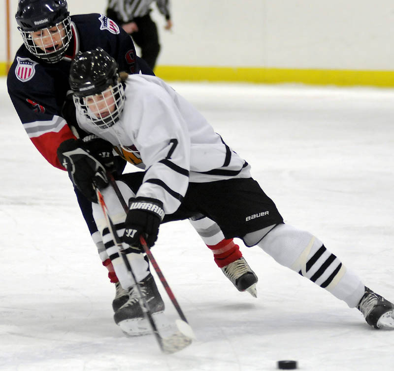 SKATING THROUGH: Maranacook/Hall-Dale/ Winthrop co-operative hockey forward Bailey Clark, right, stick handles around Gray-New Gloucester/Poland’s Ethan Callier during their game Monday in Readfield. Clark had an assist in MHW’s 4-3 victory.