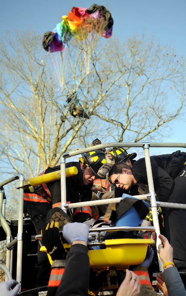 Firefighters and police lower John Beganny to the ground Sunday after rescuing him from a tree in Litchfield where he crashed a power parachute. Beganny, 66, was trapped approximately 75 feet in the air until firefighters retrieved him with a ladder truck, according Kennebec County Sheriff’s Department Sgt. Scott Taylor. Beganny sustained cuts and possible fractures in the accident and was taken to a hospital by ambulance.