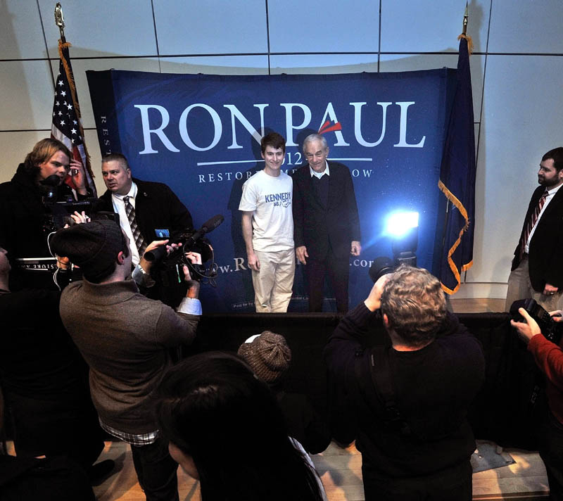 Staff photo by Michael G. Seamans Colby College senior, James Geoghegan, left, poses for a picture with Republican Party presidential hopeful, Ron Paul, at the Ostrove Auditorium at Colby College after a campaign speech on Friday.