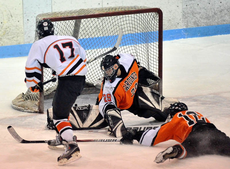 THAT’S A GOAL: Winslow High School’s Alex Bedard (17) scores an unassisted goal against Gardiner Area High School goalie Dalton Sargent center, as teammate Jeff McAuslin right, tries to defend in the first period Wednesday at Sukee Arena.