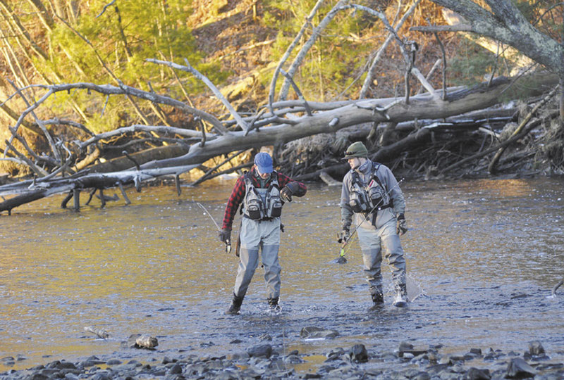 FATHER, SON TIME ON WATER: Todd Bickford and his son, Matt, of Topsham walk across the Mousam River while scouting for a fishing spot.