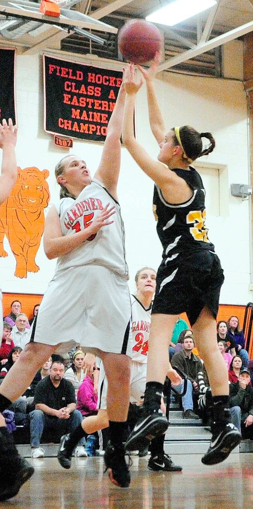 Staff photo by Joe Phelan Maranacook's Natalie Ware, right, shoots over Gardiner's Hillary Owen during a game Thursday in the James A. Bragoli Memorial Gymnasium at Gardiner Area High School.