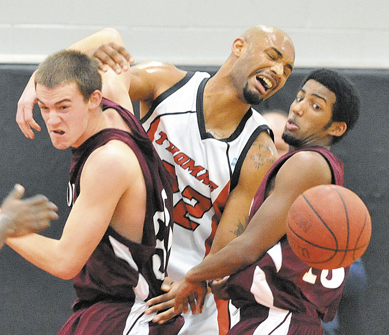 University of Maine at Farmington's Garrett Clemmer, left, and teammate Yusuf Iman battle for the ball with Thomas College's Martin Cleveland, center, in the first half Saturday at Mahaney Gymnasium at Thomas College in Waterville. Thomas defeated UMF 81-73.