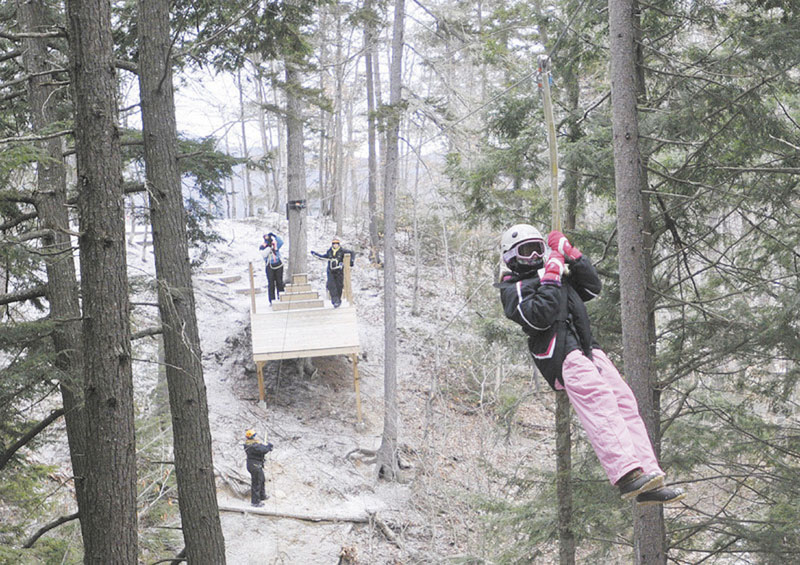 LOOKS LIKE FUN: Hannah Connell, 10, of Orlando, Fla., a moves through the forest on a zip line at Sunday River in Newry last week.