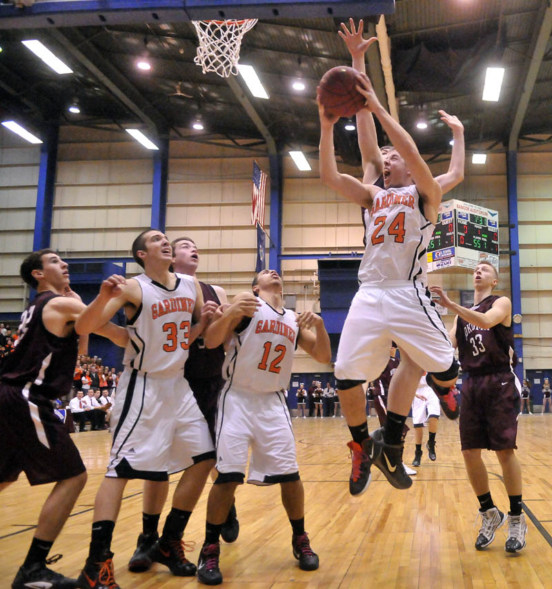 Photo by Michael G. Seamans Gardiner High School's Matt Hall, 24, right, drives to the basket in the first half of the Eastern Class B quarterfinals game at the Bangor Auditorium Friday. Gardiner won 56-47 in over time.