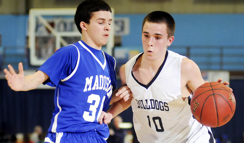 DRIVING BY: Hall-Dale High School’s Austin Bechard, right, dribbles past Madison Area Memorial High School’s Raymond Miller during a Western Class C quarterfinal game Monday at the Augusta Civic Center.