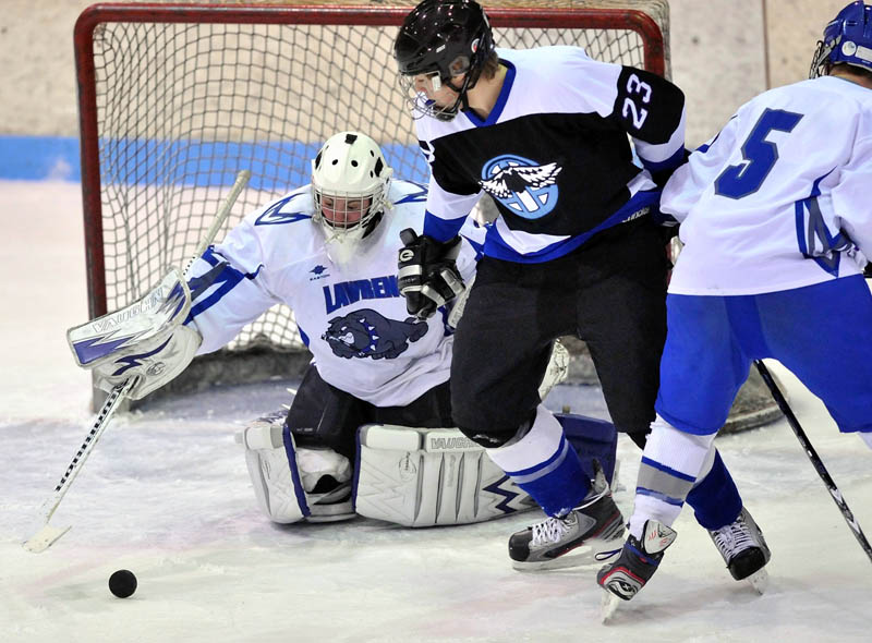 STOPPED: Lawrence goalie Kyle McLain makes a save as Houlton/Hodgdon’s Alex Casillas, right, tries to get the puck in the first period Saturday at Sukee Arena in Winslow.