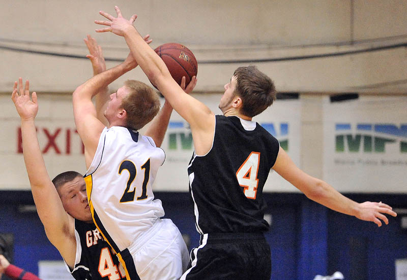 Photo by Michael G. Seamans Gardiner High School's Trevor Austin, 42, left, draws the charge from Gardiner High School's Isaac Greenrose, 21, as Gardiner's Tyler Jamison, 4, tries to block the shot in the second half of the Eastern Class B semi-finals at the Bangor Auditorium Wednesday. Gardiner defeated Medomak Valley 57-46.