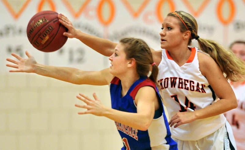 BATTED AWAY: Skowhegan Area High School’s Amanda Johnson, right, gets a hand on the ball as she defends Messalonskee High School’s Nicole Collier in the first quarter Friday night in Skowhegan.