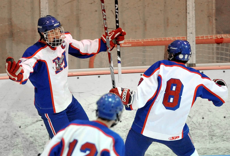 Messalonskee High School's Sam Dexter, 7, facing, turns to celebrate a goal with teammates Billy Blake, 8, right, and Chase Cunningham, 12, in the first period against John Bapst Memorial High School in an Eastern B regional quarterfinal game at Sukee Arena in Winslow Tuesday night.