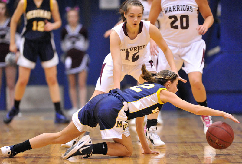 Photo by Michael G. Seamans Medomak Valley high School's Alanna Vose, 32, tries to keep control of the ball as Nokomis High School defender Kylie Richards, 12, tries to defend in the first half of the Eastern Class B quarterfinals game at the Bangor Auditorium Saturday. Nokomis defeated Medomak Valley 58-51.