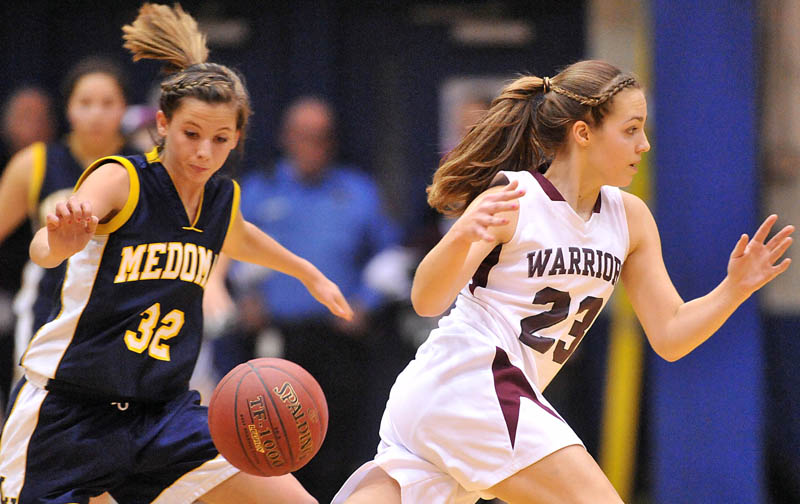 Photo by Michael G. Seamans Medomak Valley High School's Alanna Vose, 32, left, is called for a reaching foul, as she picks the ball from Nokomis High School's Kelsie Richards, 23, right, in the second half of the Eastern Class B quarterfinals game at the Bangor Auditorium Saturday. Nokomis defeated Medomak Valley 58-51.