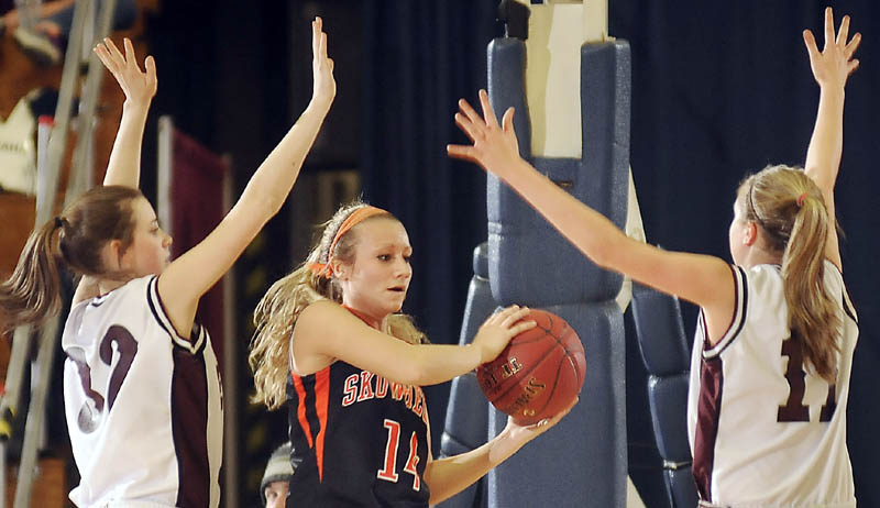 LOOKING FOR HELP: Skowhegan Area High School’s Amanda Johnson, center, looks for an opening between Edward Little’s Kelly Philbrook, left, and Tianna Harriman during an Eastern Maine Class A semifinal Wednesday at the Augusta Civic Center. Johnson scored seven points in Skowhegan’s 54-34 loss.