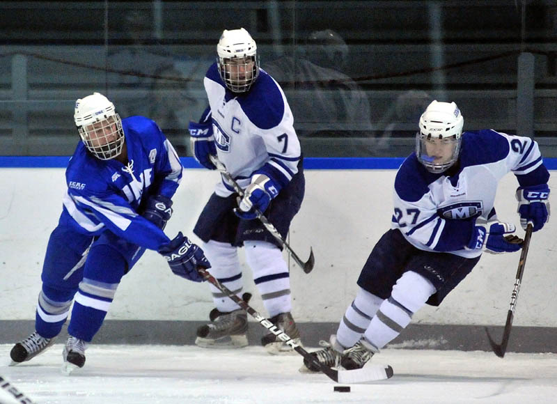 Feels like home: University of New England’s Ted Fabian, left, gathers the puck in front of Colby College’s Patrick Bursee in the first period Tuesday night at Colby College’s Alfond Arena at Colby College in Waterville.