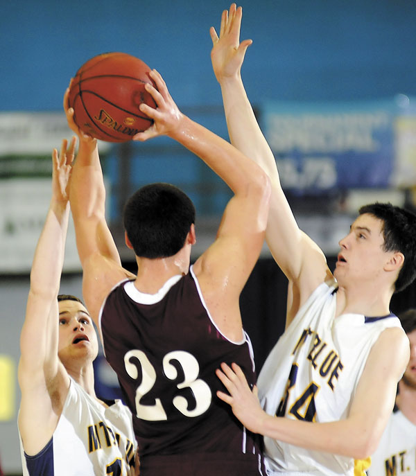 YOU’RE SURROUNDED: Mt. Blue High School’s Chris Malone, left, and Cameron Abbott defend Edward Little’s Quin Leary during an Eastern Maine Class A semifinal Wednesday night at the Augusta Civic Center. Mt. Blue won 52-49 and advanced to the regional final at 8:45 p.m. Friday.
