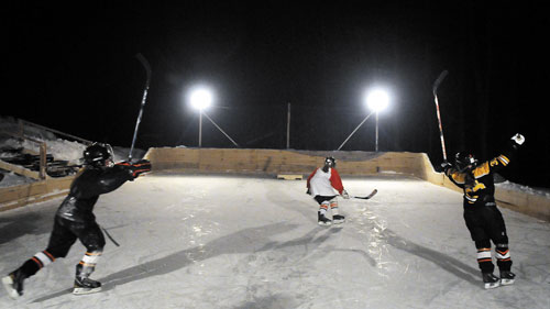 IT’S GOOD: Girls celebrate scoring a goal during a game of shinny hockey at John Hinkley’s lighted rink in West Gardiner.
