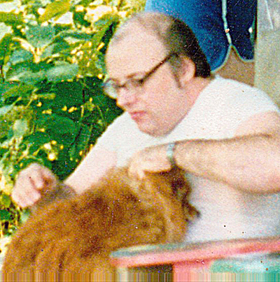 An undated family photo of Sherwood Campbell caring for one of his dogs.