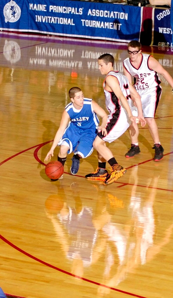 Valley's Caleb Wade, left, tries to drive around Forest Hills defenders Matthew Turner and Derick Ouellette during the Class D West tournament on Wednesday morning at the Augusta Civic Center.