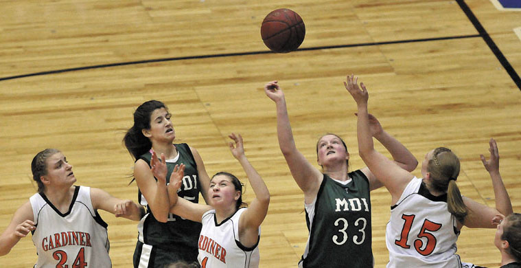 Photo by Michael G. Seamans Players fight for the rebound in the first half of the Eastern Class B quarterfinals game at the Bangor Auditorium Saturday. Gardiner defeated MDI 63-38.