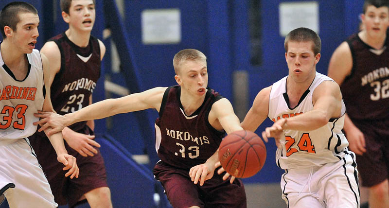 Photo by Michael G. Seamans Nokomis High School's Drew Wing, 33, left center, and Gardiner High School's Matt Hall, 24, battle for the ball in the second half of the Eastern Class B quarterfinals game at the Bangor Auditorium Friday. Gardiner won 56-47 in over time.