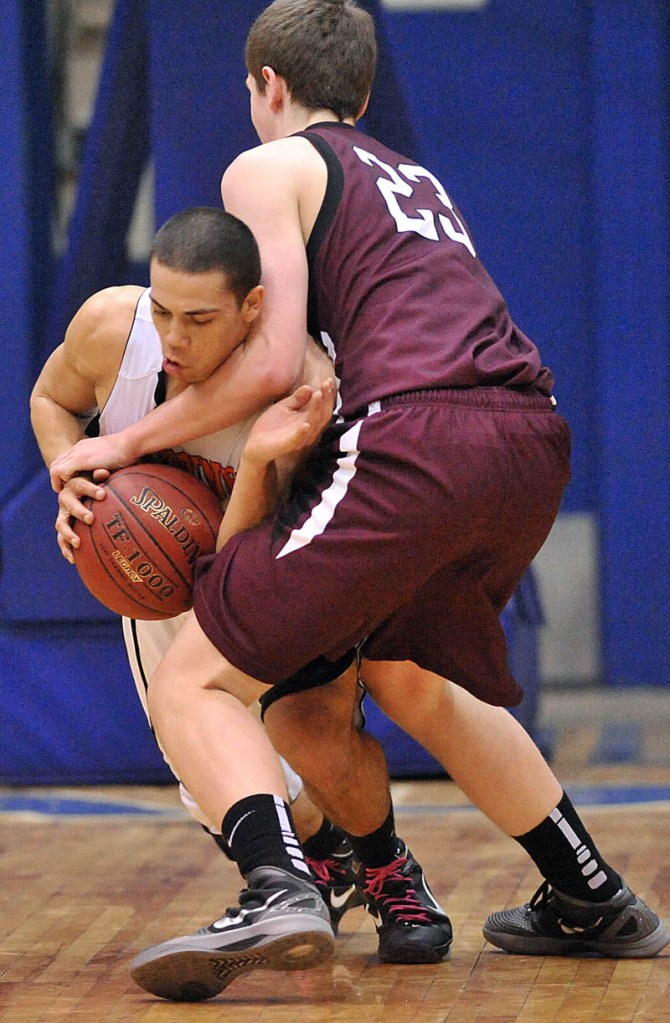 Photo by Michael G. Seamans Gardiner High School's Alonzon Connor, 12, facing, and Nokomis High School's Andrew Cartwright, 23, fight for the ball in the first half of the Eastern Class B quarterfinals game at the Bangor Auditorium Friday. Gardiner won 56-47 in over time.