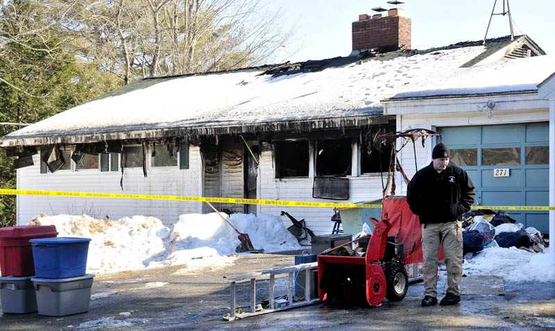 DOUBLE FIRE: Edward Hastings, an investigator with the state Fire Marshal's Office, walks around salvaged items belonging to Matthew Fine at his home that was gutted by two accidental and separate fires Sunday on River Road in Norridgewock.