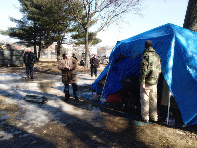 Portland police watch as people dismantle the last structure standing in Lincoln Park today.