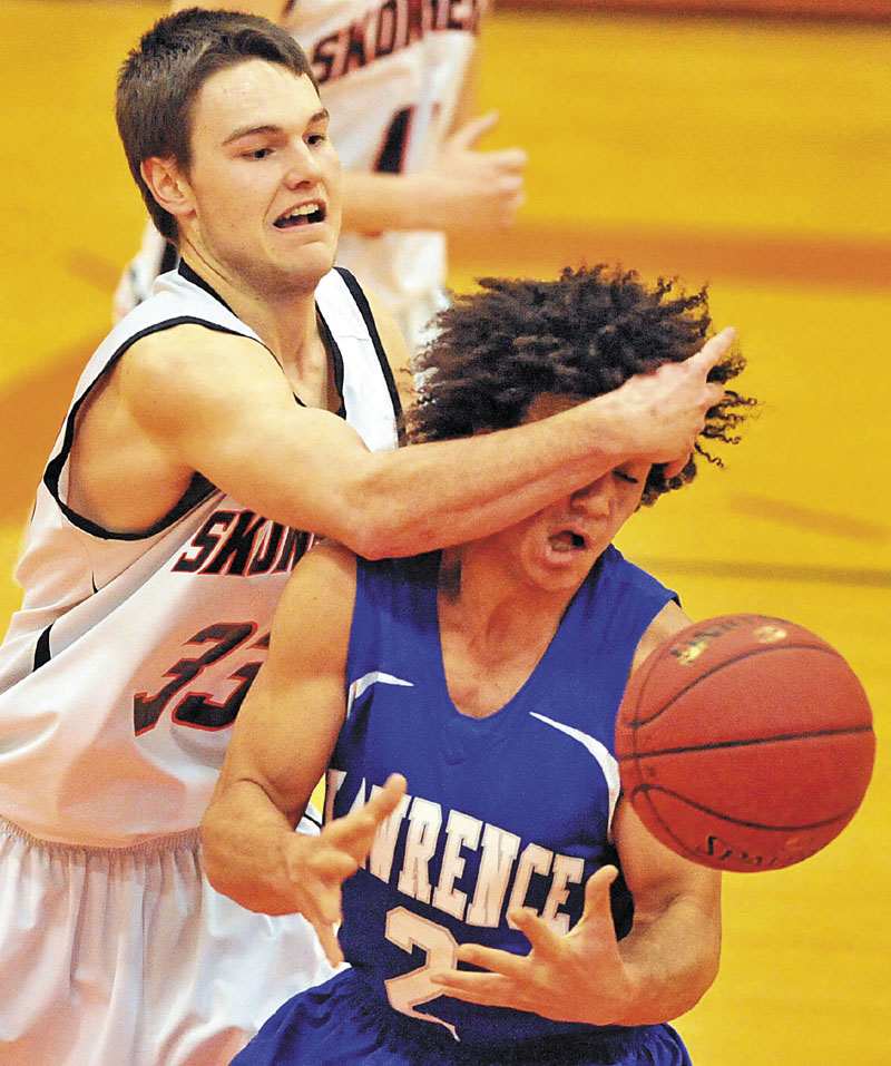 OUCH: Skowhegan Area High School’s Ethan Johnson,left, battles for the ball with Lawrence High School’s Shaun Carroll on Thursday in Skowhegan.