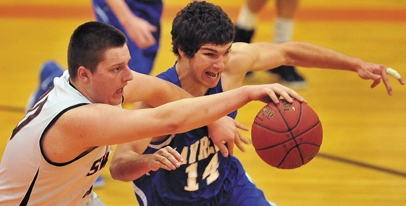 Staff photo by Michael G. Seamans Skowhegan High School's Taylor Bacon, 40, fights for the loose ball with Lawrence High School's Spencer Carey, 14, right, in the first quarter at Skowhegan High School Thursday night.
