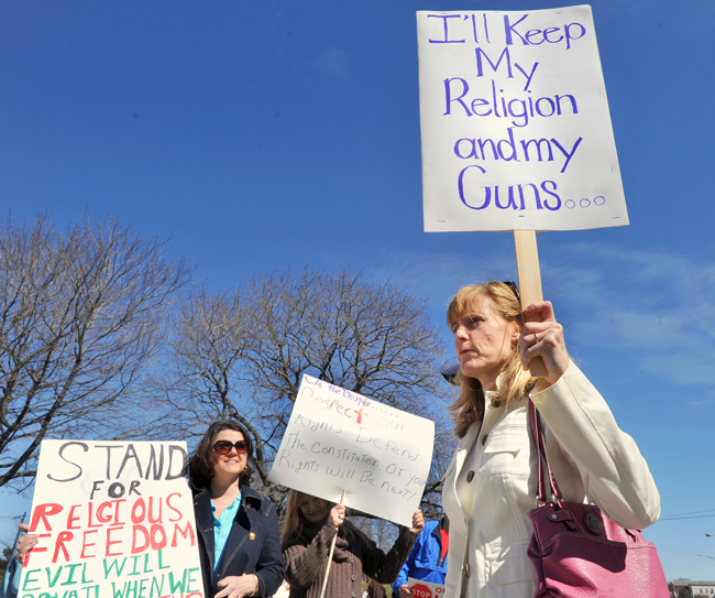 Suzanne Ennis of Gorham shares her viewpoint on her sign while attending the Rally for Religious Freedom on Federal Street in Portland this afternoon.