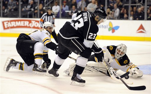 Boston Bruins goalie Tim Thomas (30) and defenseman Dennis Seidenberg (44) stop Los Angeles Kings right wing Dustin Brown (23) from scoring in the second period of an NHL hockey game in Los Angeles, Saturday, March 24, 2012. (AP Photo/Lori Shepler)