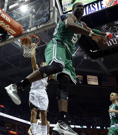 Milwaukee Bucks' Carlos Delfino, back left, dunks behind Boston Celtics' Mickael Pietrus (28) during the second half of an NBA basketball game on Thursday, March 22, 2012, in Milwaukee. (AP Photo/Jeffrey Phelps)