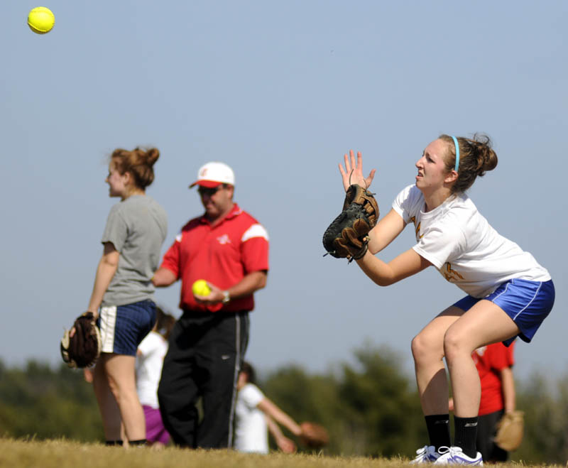 THE GREAT OUTDOORS: Cony High School softball player Nicole Rugan plays catch Monday on the school’s practice field. Catchers and pitchers reported for the first day of practice.