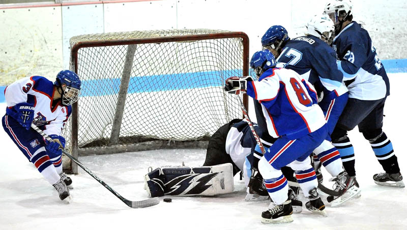 Messalonskee High School's Joshua Towle, 3, left, picks up the rebound for an early first period goal against Presque Isle High School in the eastern regional play-off game at Sukee Arena in Winslow Saturday.