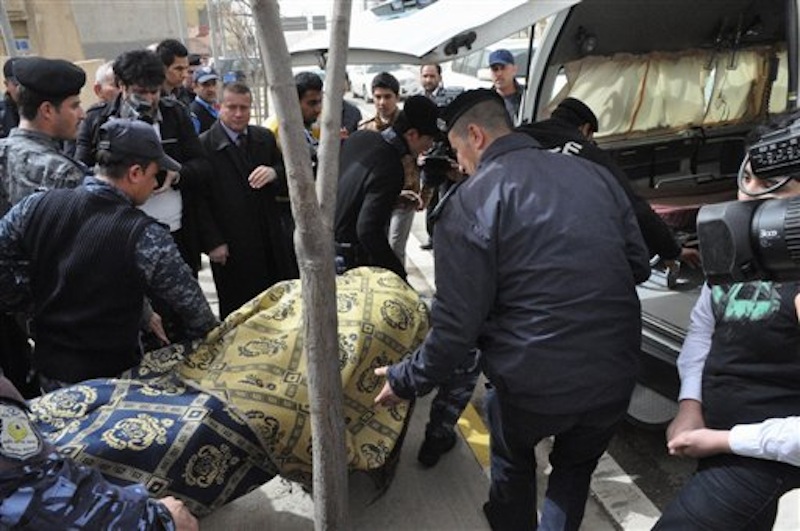 The body the slain American gym teacher is carried out of the school in Sulaimaniyah, 160 miles (260 kilometers) northeast of Baghdad, Iraq, Thursday, March, 1, 2012. An American gym teacher was killed Thursday when a student in the crowded classroom pulled out a gun, shot the teacher and then shot himself, officials and eyewitnesses said. (AP Photo/Yahya Ahmed)