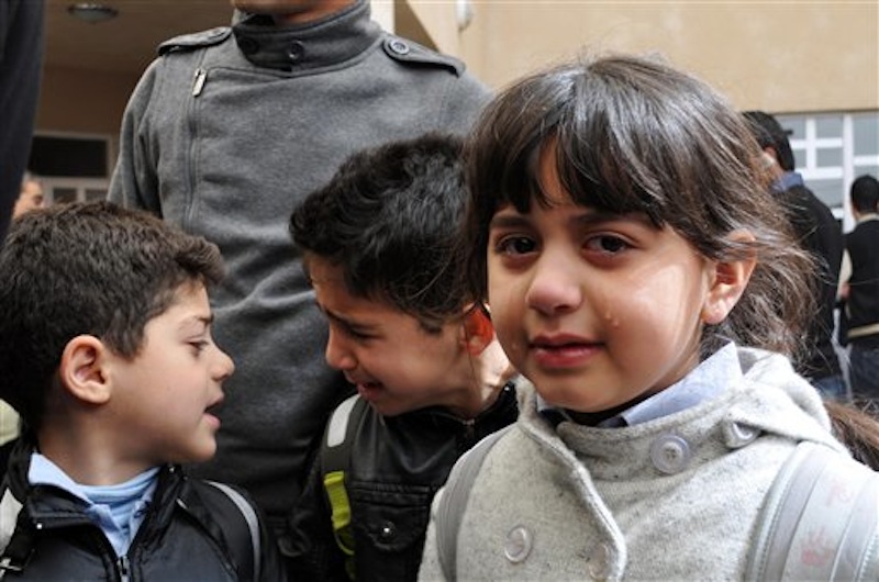 Students cry in the schoolyard after a fatal shooting of an American gym teacher at a school in Sulaimaniyah, 160 miles (260 kilometers) northeast of Baghdad, Iraq, Thursday, March, 1, 2012. An American gym teacher was killed Thursday when a student in the crowded classroom pulled out a gun, shot the teacher and then shot himself, officials and eyewitnesses said. (AP Photo/Yahya Ahmed)