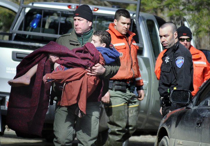 Marine Patrol Officer Donaldson Boord carries 12-year-old Micah Thomas from a boat this afternoon on the Eastern River in Dresden to an ambulance after searchers discovered the boy in a smelt shack.