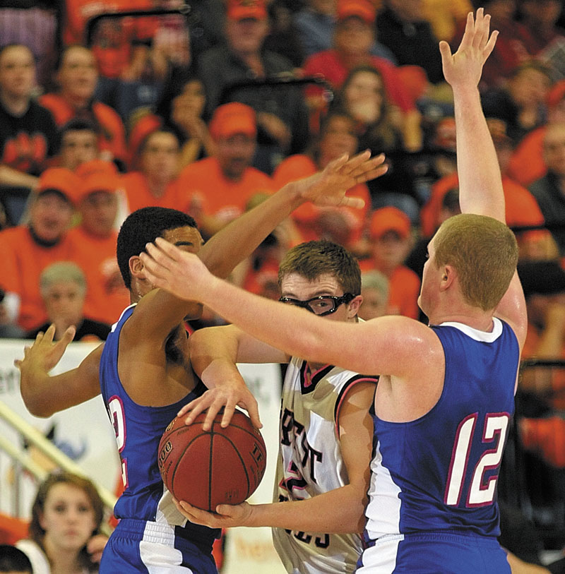 Forest Hills junior guard Derick Ouellette, middle is doubled up by Jonesport-Beals defenders Leon Smith, left, and Thomas Beal during the Class D state championship game on Saturday afternoon at the Augusta Civic Center.