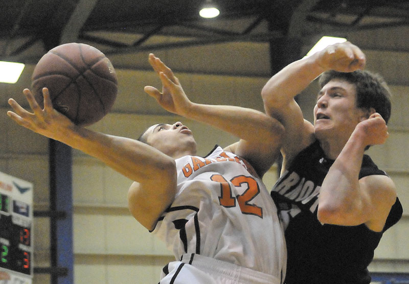 AND THE FOUL: Gardiner Area High School’s Alonzo Connor, left, is fouled on the shot by Yarmouth High School’s Nathaniel Shields-Auble in the first quarter in the Class B state championship game Friday at the Bangor Auditorium.