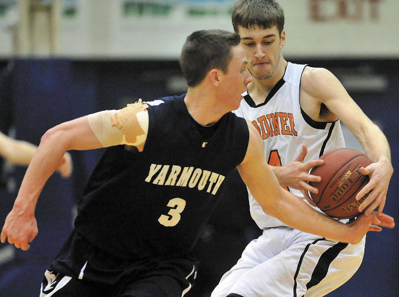 Gardiner High School's Tyler Jamison, 4, fights for the ball with Yarmouth High School's Joshua Britten, 3, in the second half of the Class B State Championship at the Bangor Auditorium Friday night. Yarmouth defeated Gardiner 65-53.