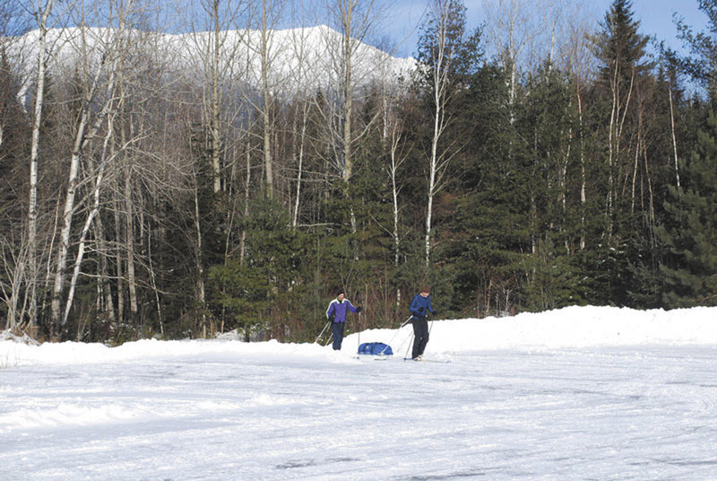 EPIC VIEWS: Eric Pandiscio, left, of Orono and John Gause of Bangor ski out of Baxter State Park after a ski and hike trip up Mount Katahdin, seen in the distance. Mount Katahdin is now open to fewer than four hikers at a time during the winter.