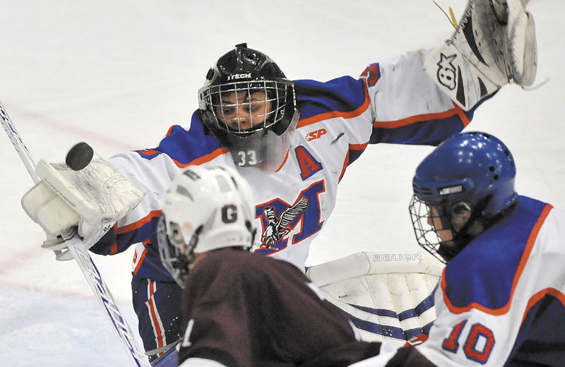 Photo by Michael G. Seamans Messalonskee High School goalie, Nate DelGiudace, 33, makes a blocker save against Greely High School in the second period of the Class B Boys hockey state championship game at the Colisee in Lewiston Saturday..