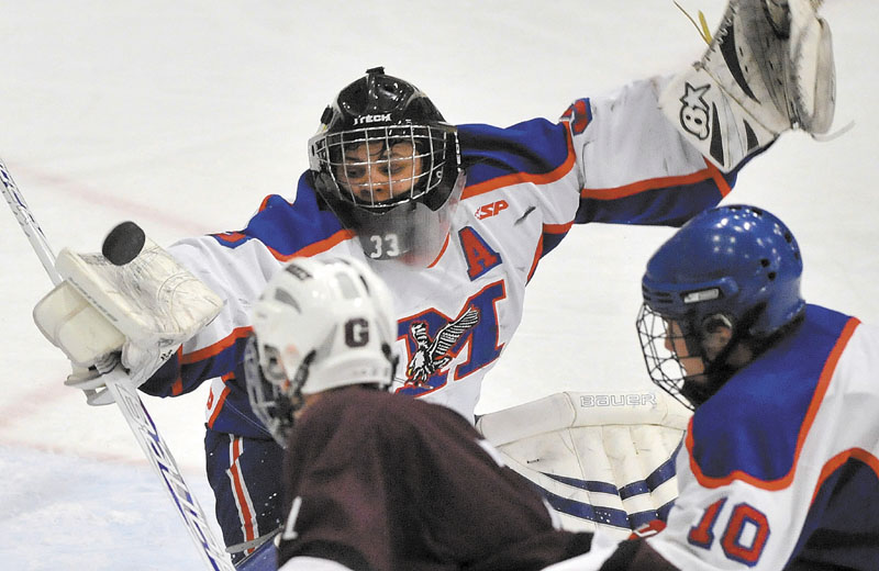 SHOT, SAVE: Messalonskee High School goalie Nate DelGiudice makes a save against Greely High School in the second period of the Class B boys hockey state championship game Saturday at the Colisee in Lewiston.