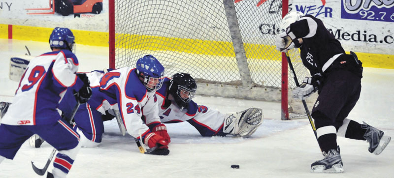 Photo by Michael G. Seamans Messalonskee High School's Nate DelGiudace, 33, center, Tyler Simpson, 24, left center, and Travis St. Pierre, 19, left, try to defend Greely High School's Mitchel Donovan, 7, right, in the third period of the Class B Boys hockey state championship game at the Colisee in Lewiston Saturday. Greely won 6-2.